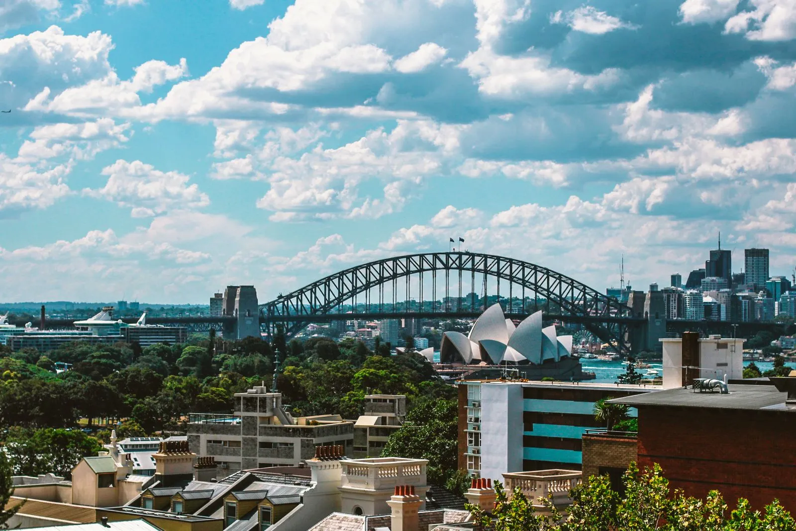 Stunning view of Sydney Harbour Bridge and Sydney Opera House on a sunny day, showcasing the vibrant cityscape.